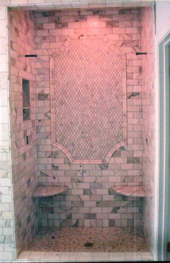 Marble subway shower with diamond lattice inset panel and arched shelves