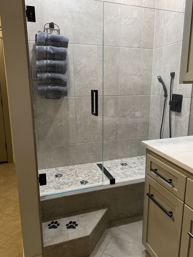 Custom dog wash bay with glass enclosure and tiled bench