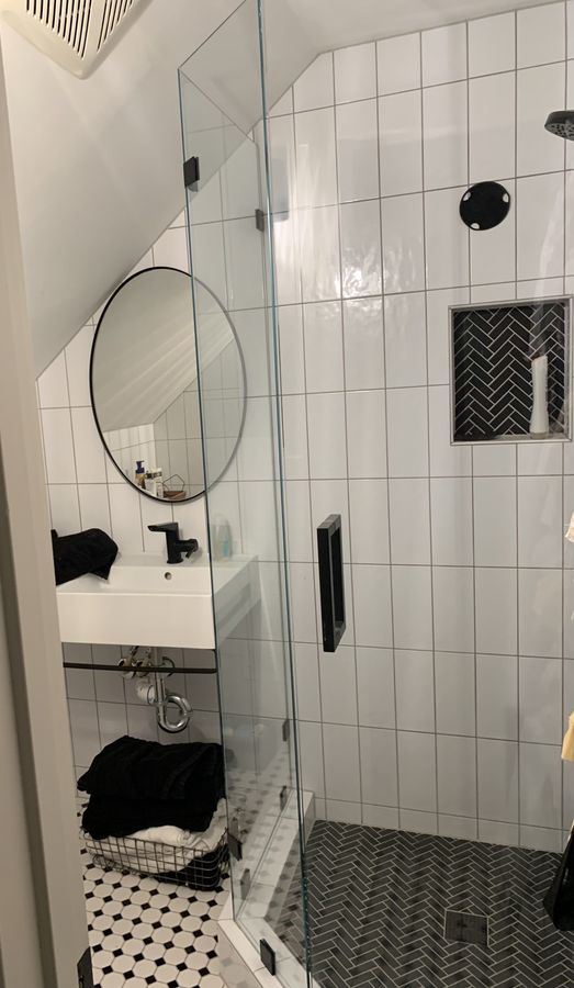 Attic dormer bathroom with white square tile and round mirror