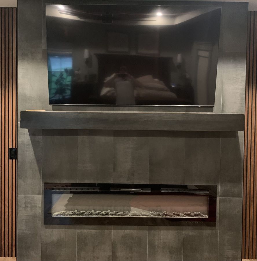 Fireplace and media wall in large format concrete look porcelain