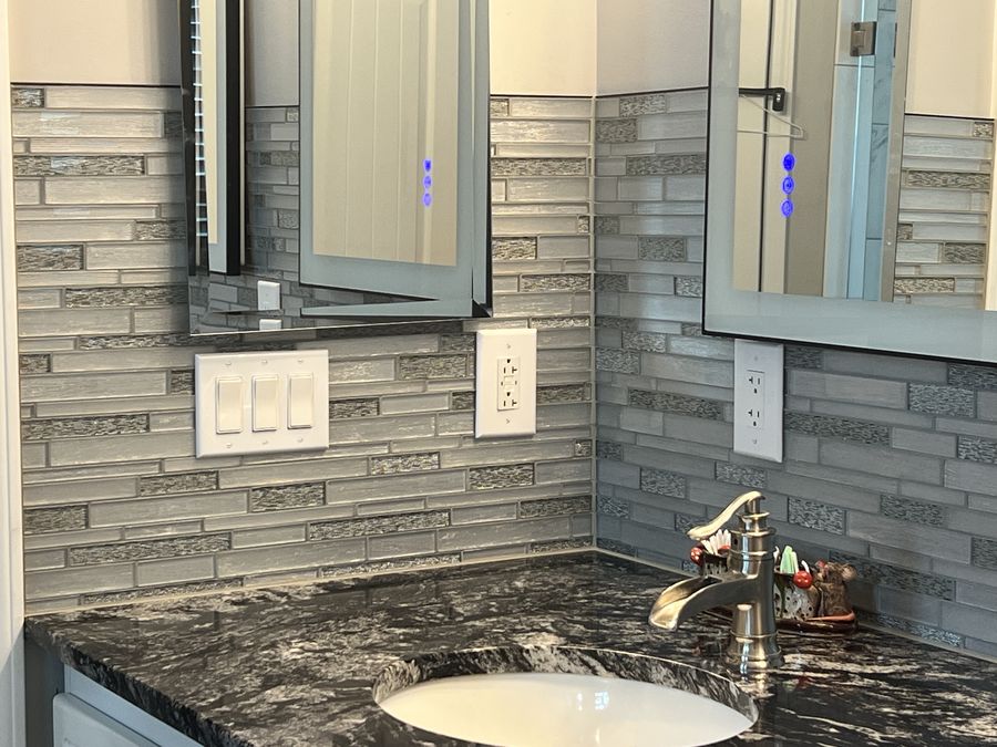 Vanity corner with linear glass mosaic and switch plates