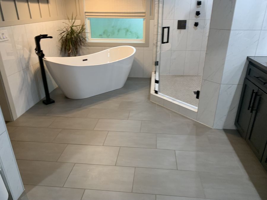 Large format grey porcelain master bath floor with freestanding tub
