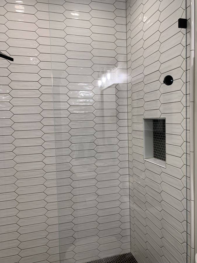 White picket tile shower wall with matte black fixtures